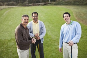 Multi-ethnic men playing golf.
