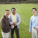 Multi-ethnic men playing golf.